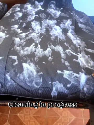 Foam treatment on a car seat during interior cleaning