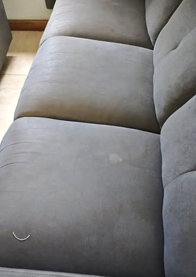 Grey fabric recliner sofa with marks on the seat cushions before cleaning