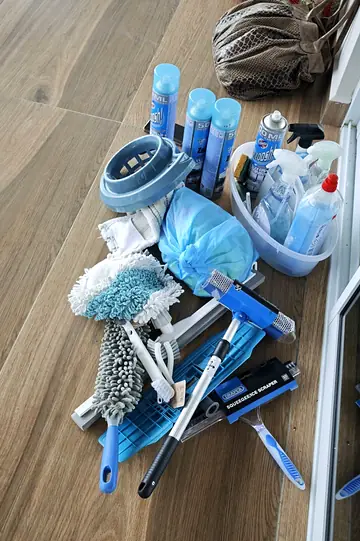 Window squeegees, microfibre mops and glass cleaners laid out for a job